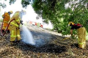 Wodonga firefighters tend to a small grass fire at Les Stone Park near Ebden Street yesterday afternoon. Pictures: JOHN RUSSELL